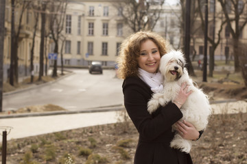 Beautiful blonde woman playing with dog  in the park