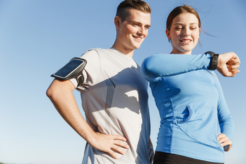 Runner woman with heart rate monitor running on beach