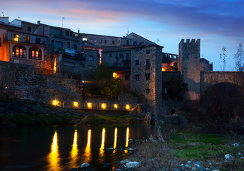 Evening photo of medieval town on banks of river. Besalu