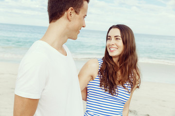 Romantic young couple standing on the beach