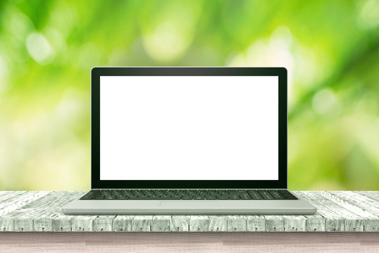 laptop computer on wood table green background