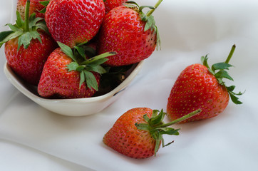 Fresh Strawberries In Bowl On White Fabric Background.