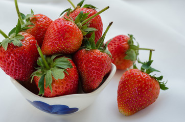 Fresh Strawberries In Bowl On White Fabric Background.