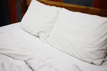 Messy white bed and pillow, in the morning