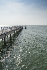 Obraz premium The wooden bridge walkway into the sea.