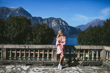girl in a beautiful dress standing on the viewpoint with views of Lake Como