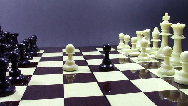 Chess board with pieces arranged at the beginning of a game , and unexpected opening with white and black pawns switching sides and  advancing towards the center of the board