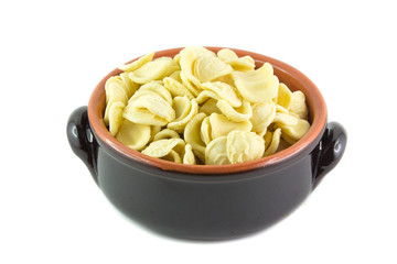 Orecchiette crude in un tegame di terracotta