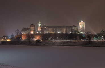 Royal castle on the Wawel hill, Krakow, Poland, over frozen Vistula river, winter night