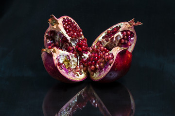 Broken Azerbaijani pomegranate isolated on black