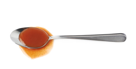 Steel spoon in a puddle of hot sauce