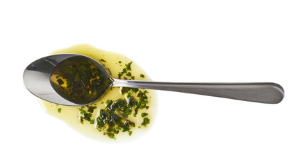 Steel spoon in a puddle of olive oil