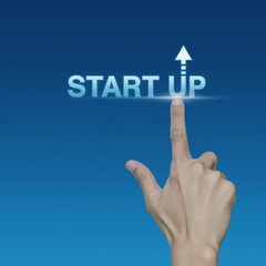 Hand click on start up icon over blue background, Start up busin