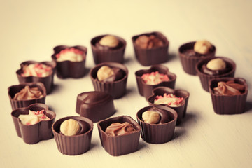 Set of chocolate candies on light wooden background, close up