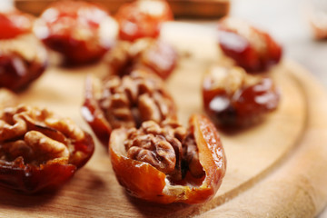 Walnut, date fruit on wooden table, close-up