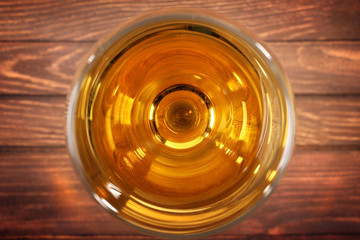 Glass of wine on wooden table. Top view