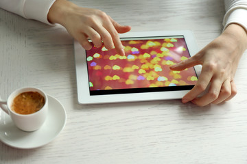 Fototapeta na wymiar Woman using digital tablet on table close up
