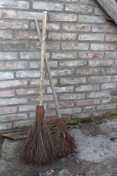 Brooms of branches on the brick wall background
