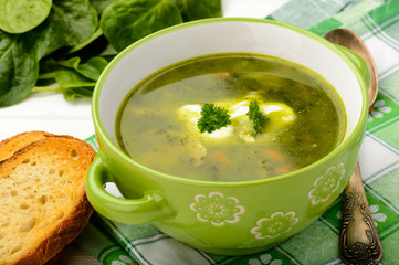 Vegetarian soup with vegetables as carrot, spinach, potatoes, parsley and mushrooms.
