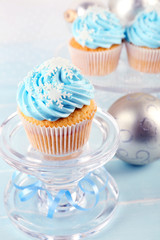 Few tasty blue cupcakes with decorations on light background