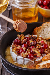 Homemade baked brie with honey, cranberry and walnut.