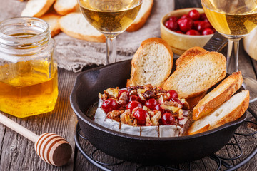 Homemade baked brie with honey, cranberry and walnut.