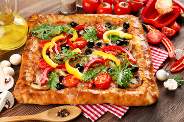 Freshly homemade pizza on wooden table closeup