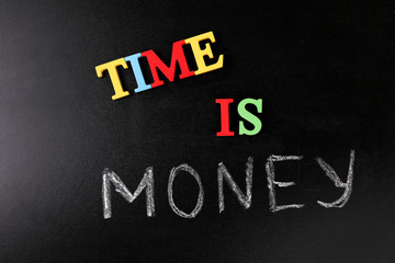 Time is money concept on a blackboard background