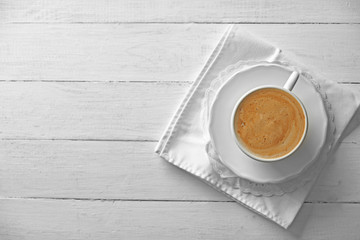 Cup of coffee with foam on wooden background