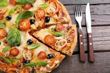 Delicious fresh pizza on wooden table closeup