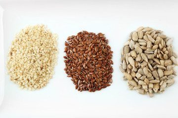 Sesame, flax and sunflower seed in plate on wooden table