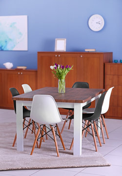 Modern living room. Furniture set with table and chairs. Bouquet of beautiful white and purple tulips on the table