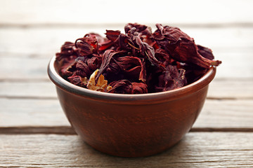 Hibiscus tea in a round bowl on wooden table, close up