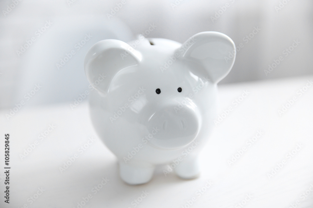 Wall mural Savings concept. Piggy bank on white table, close up