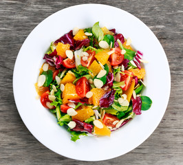 Fresh Orange, strawberry vegetables salad. on wooden table.