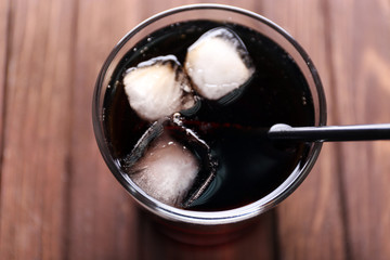 Cocktail with ice blocks and tubule  on wooden background, top view