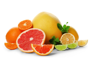 Mixed citrus fruit including lemons, grapefruits, tangerines, orange and pomelo with mint sprigs isolated on a white background, close up