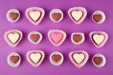 Tasty candies for Valentines Day on purple background
