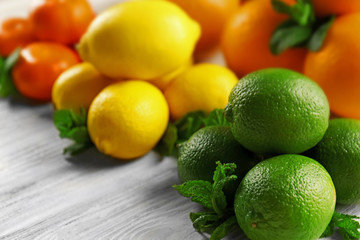 Set of different citrus fruit on light wooden table