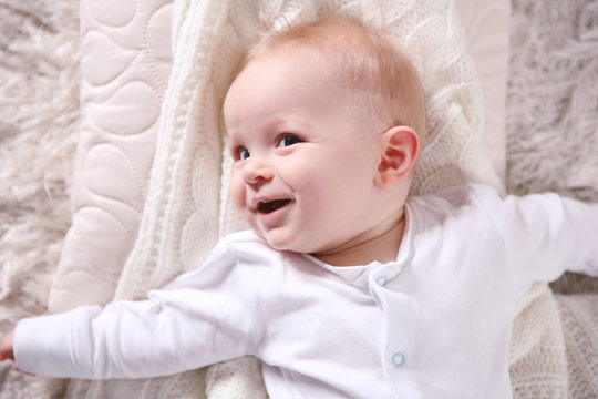 Portrait of adorable smiling baby on the floor, close up