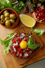 Beef tartare served on a wooden board, top view