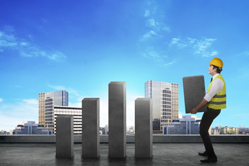 Asian worker lifting heavy block chart