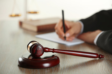 Judge writing on paper at desk indoors