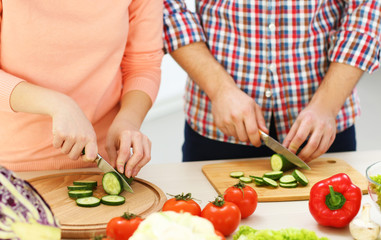 Happy couple cooking salad on the kitchen, close up