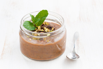 chocolate dessert with pistachios in a glass jar