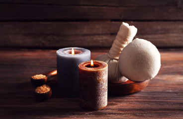 Spa composition with alight candles and massage balls on wooden background