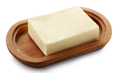 Fototapeta na wymiar Piece of butter on wooden plate, closeup