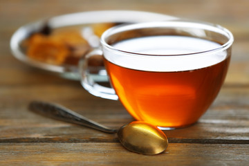 Glass cup of tea on wooden table against blurred background