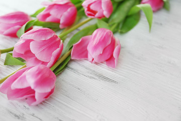 Fresh pink tulips on a wooden table, close up