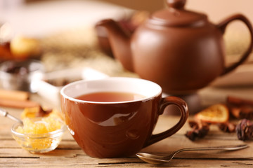 Cup of tea with spices and honey on wooden table closeup